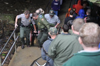 Rangers carrying a person out of the cave