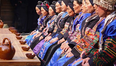 Long skirt Miao women at rice wine table