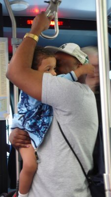 father & son stay close on subway