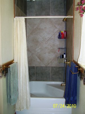 An older version of our bathroom, after our third remodel, showing the original bath tub that we kept but tiled around.  The bathtub is unique, about 4 x 4 in size with two seating areas to it. When we did our final bathroom remodel (turning it into an ensuite master bath and small powder room) we tried saving this tub base to re-sell but it was severely damaged in trying to get it out.