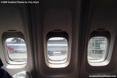 Three windows providing a view from my window seat onboard Northwest Airlines B747-451 N664US before takeoff