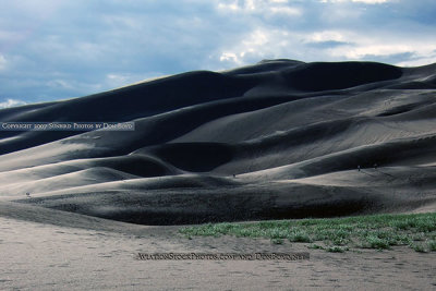 2007 - a couple of people climbing dunes at the Great Sand Dunes National Park in the late afternoon after a thunderstorm
