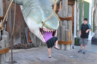 Child climbs into the mouth of mockup of a shark inspired by movie Jaws (1975). Universal Studios, Hollywood.