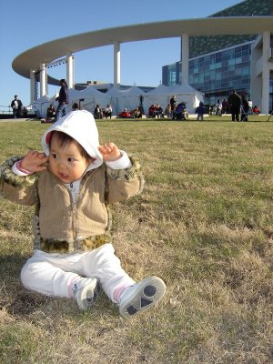 歡歡坐在 Long Center 前的草地上