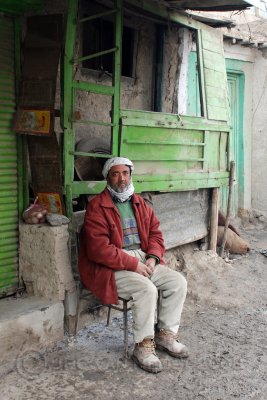 Man sitting in front of his shop...
