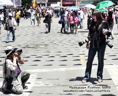 Photo was taken during my live TV coverage of the festival parade. I was holding two cameras while my microphone is in my back pocket. The third camera is from my friend for pictorial purposes. :-)