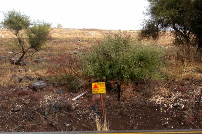 Minefield warning sign next to a road in the Golan Heights. Mines were deployed by the Syrian army and some remain active.