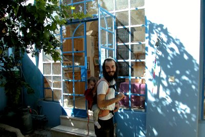 Husband of Sheva Chaya Shaiman and their child in front of their shop in the Artists Quarter in Tzfat.