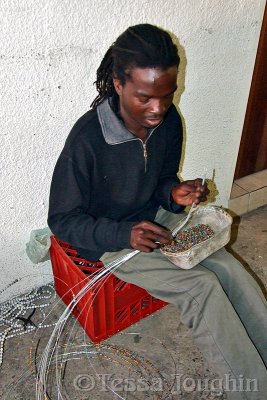 Bead artist loading beads onto the wires.
