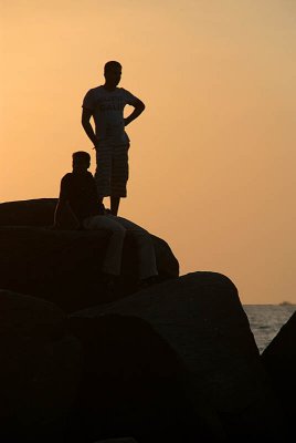 Silhouetted Figures on Rock at Sunset Palolem