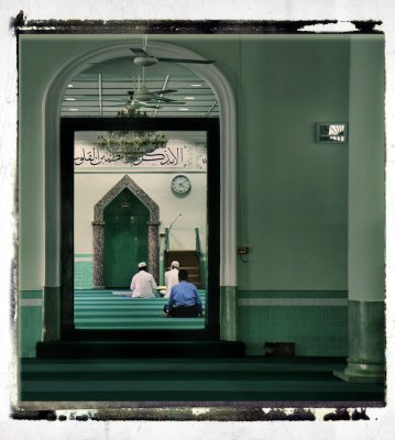 muslims praying in the male section of a mosque