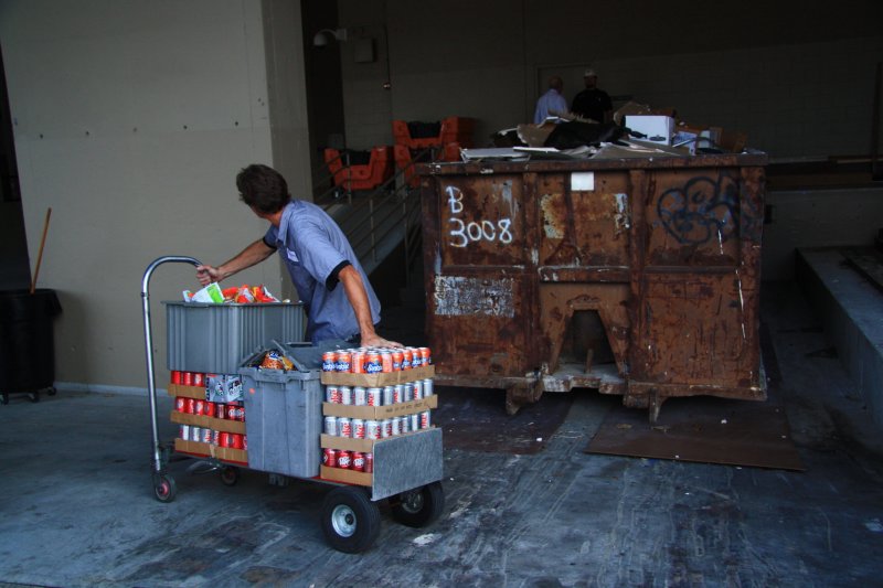 MOVING CANS IN FRONT OF A DUMPSTER