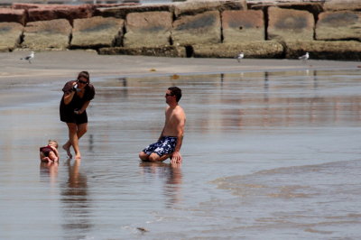 FILMING THEIR DAUGHTER ON THE BEACH