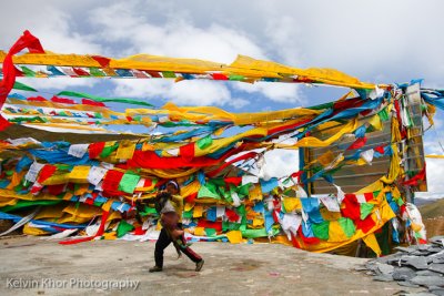 A young girl hanging her prayer flag, Milha Pass