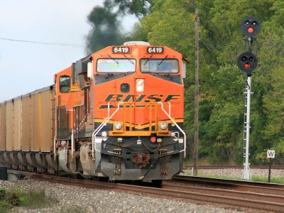 BNSF power leads a loaded PRB coal train across the diamond at Butler