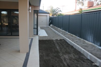 The rich soil is in place for the lawn, the lighter soil area will be paved, a raised garden bed alongside the fence