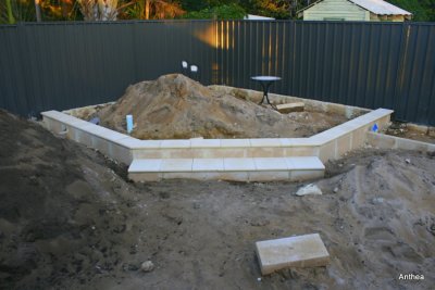 The raised feature currently in progress, this area is to be partly paved, a small table, a specimen tree and a pond.
