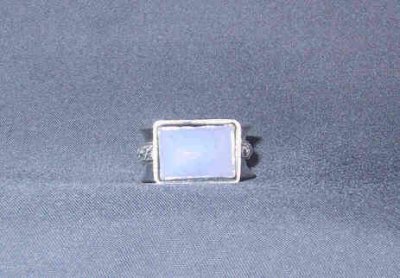 This size 7.5 ring has a wide band with a patterned overlay. The stone is a 10 x 14 mm chalcedony.