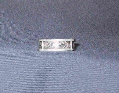 This ring has a patterned band rivetted in between two sheets of silver.  Size 6.5.  SOLD