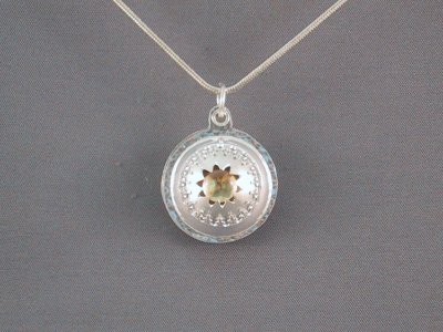 This pendant is actually a 2.5 cm diameter locket. It bears an 8mm citrine on the front.