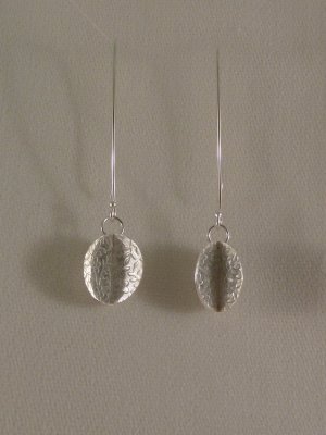 Long drop earrings with inter-locked, flower-printed discs. Sold