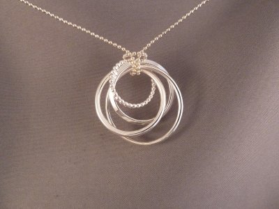 Four sterling silver circles of varying sizes and textures.