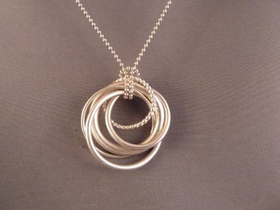 Five intertwined sterling silver circles on an 18 sterling silver ball chain.