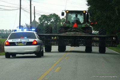 On my way to work, the farm machine blocked the road as the officer responded to a call.