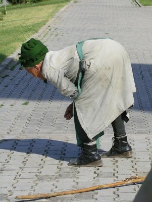 Fergana, Uzbekistan - This old woman's job is to pick out grass between pavers