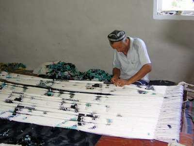 Margilan - old silk factory - man preparing silk threads for ikat dying