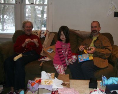 Grandma knitting, Evie starting to look awake, Dad with Rhino the Zhu Zhu