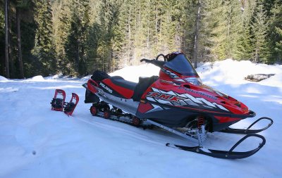 Tools To WInter Paradise ( Snowmobile And Snowshoes Strapped On Back )