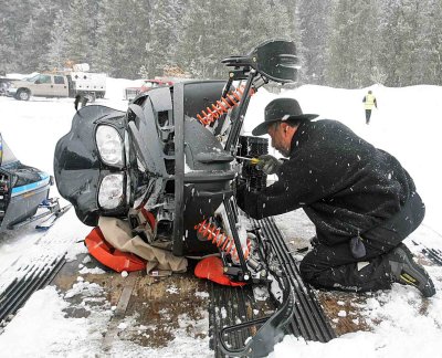 Fixing His Snowmobile, Volunteer Hurries To Make Quick Repair