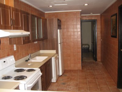 Kitchen looking towards the laundry area and at end of hall, maid's room.