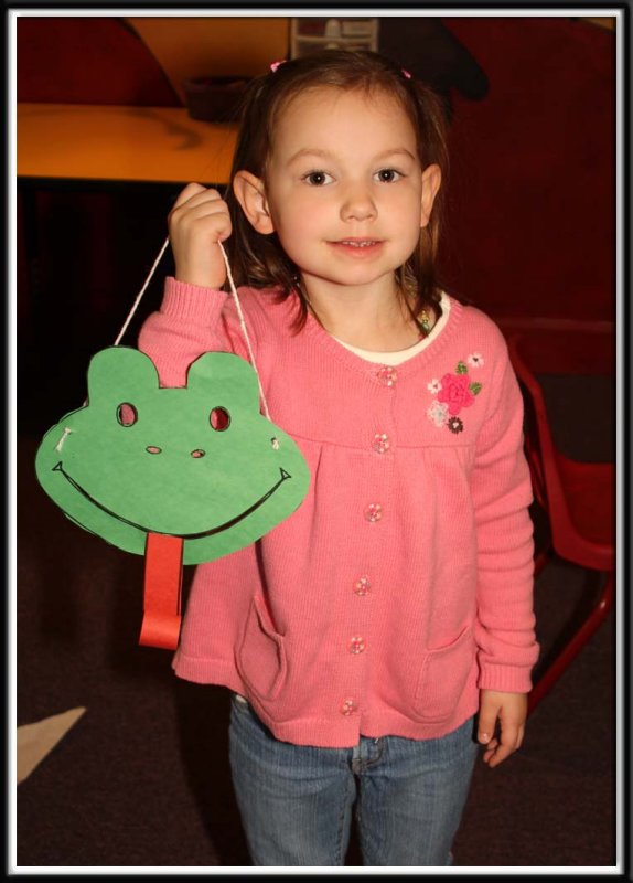 Noelle makes a frog mask in the craft center