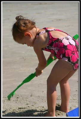 Little Kylie helps rake sand