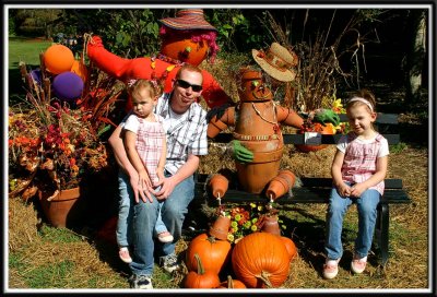 Daddy and the girls with a statue made of clay pots