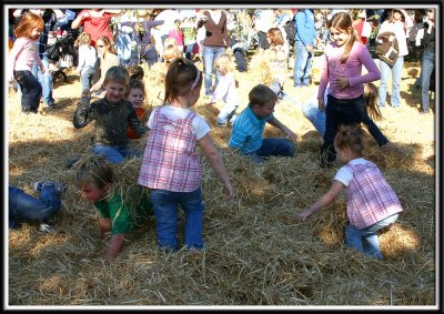 Noelle and Kylie wade through the hay with the other kids