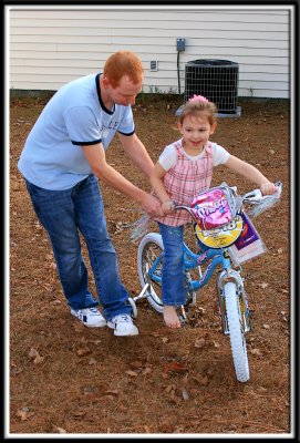 Daddy helps Noelle ride her bike