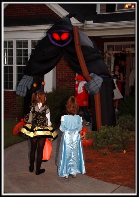 Noelle and Kylie are very scared to walk under the freakishly large blow up grim reaper
