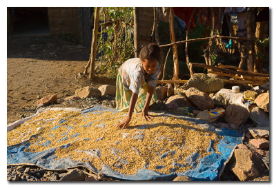 Nia secando grano de sorgo en la calle  -  Girl drying sorghum