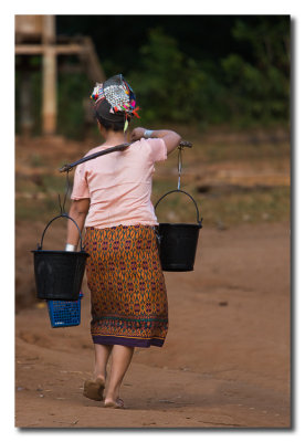 Seora con dos cubos de agua  -  Lady transports two water buckets