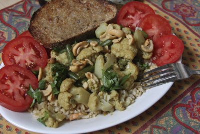 Cashew curry on brown rice with sliced tomatoes and toasted whole grain bread