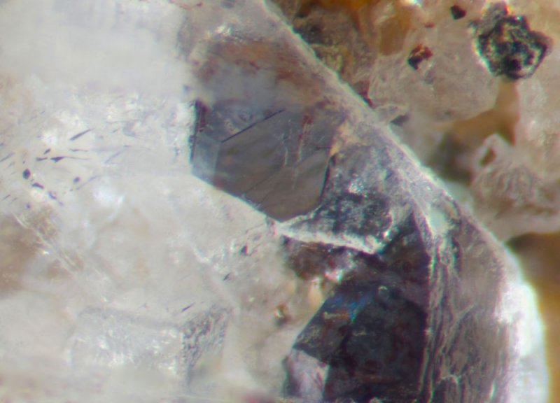 Pristine galena cuboctahedra and a colourless fluorite cube seen through the window of a 5 mm Wetgrooves barite crystal.