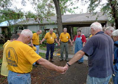 THE TEAM PRAYS WITH THE HOMEOWNER, BEFORE STARTING THE DAY'S WORK