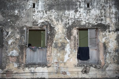 Dilapidated building with two windows with laundry