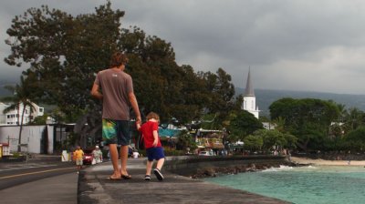 Father and son walking the sea wall in Kona