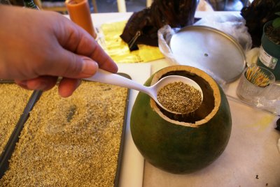 Add dried millet to gourd.JPG