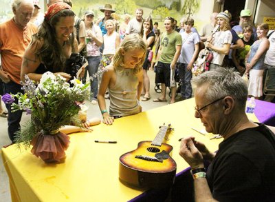 Tommy Emmanuel signs a mini-guitar for a fan