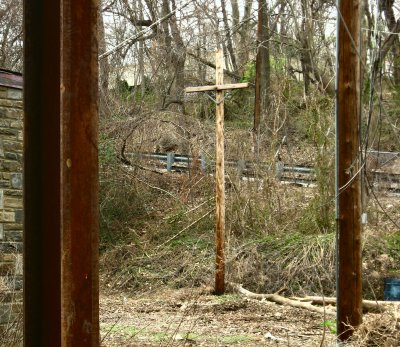 A utility pole framed by supports for the electric wires